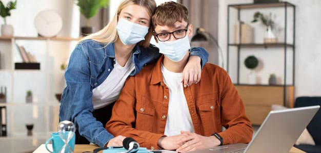 students with face masks holding one another
