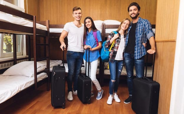 Students with luggage posing at accommodation in the UK