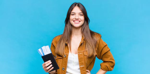 a female student posing with a passport in her right hand